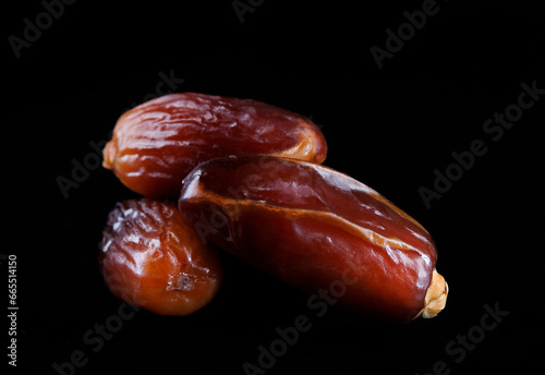 Several ripe dates on a black background. Delicious dates on black.