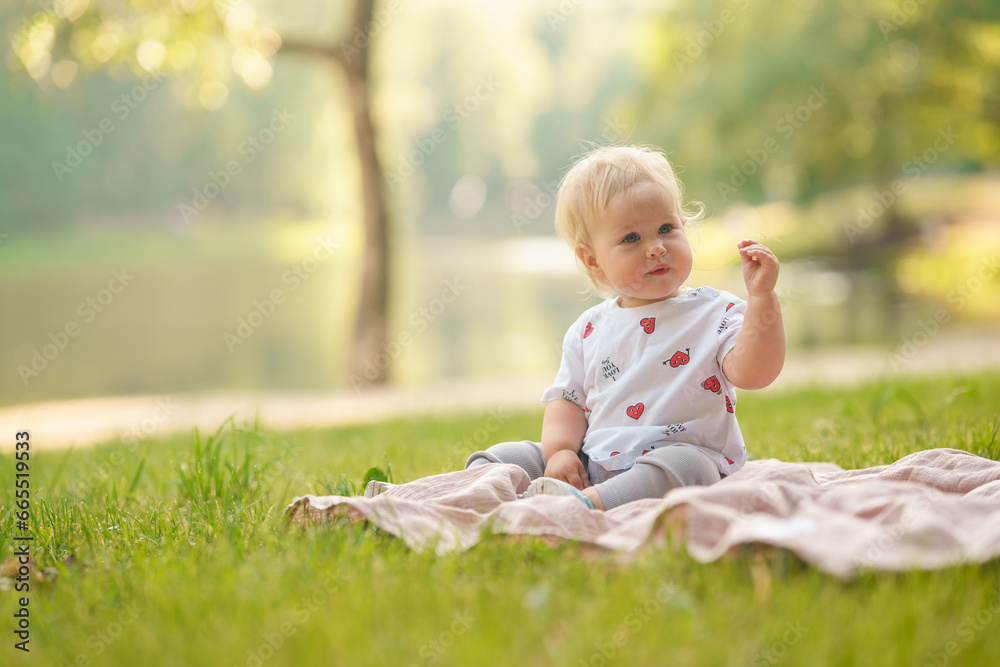 Caucasian little child baby in the park in summer in the setting sun, outdoor walking Caucasian little child baby in the park in summer in the setting sun, outdoor walking
