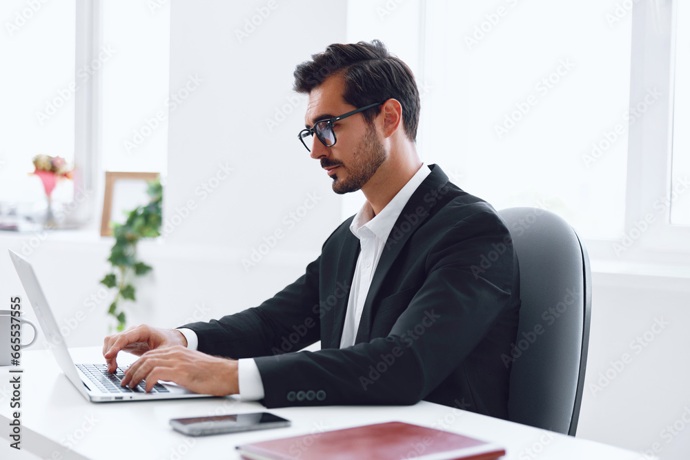 Man in office businessman sitting at desk and working in laptop, finance and startup concept, working lifestyle in bright office. Man in office businessman sitting at desk and working in laptop, finance and startup concept, working lifestyle in bright office.
