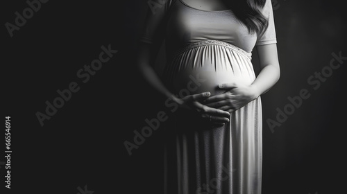 Gros plan sur le ventre d'une femme enceinte en train de tenir son ventre avec ses mains.