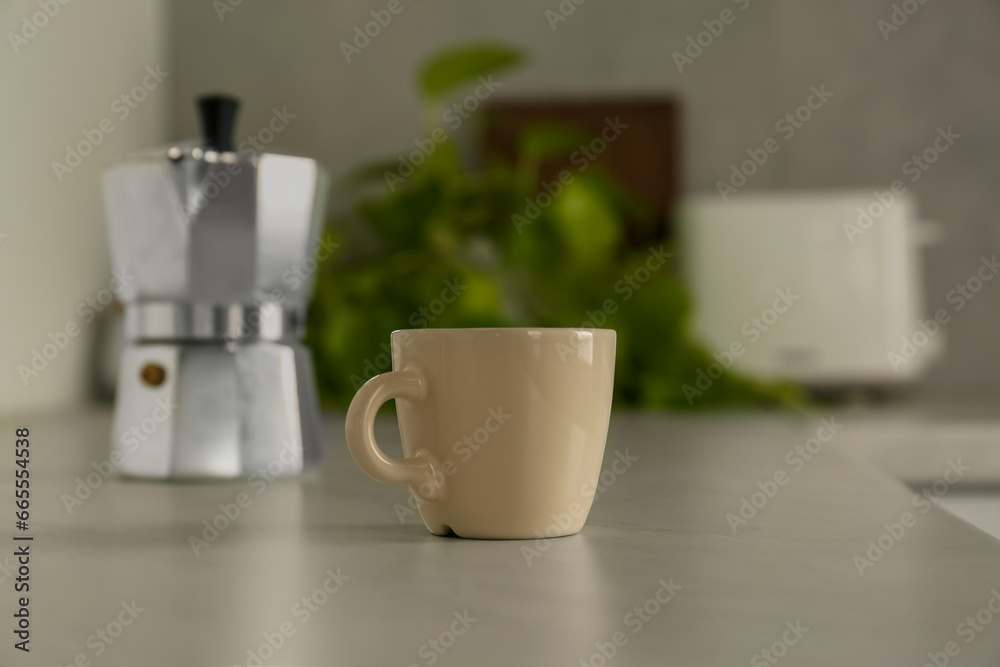 Obraz premium One ceramic cup on light grey countertop in kitchen
