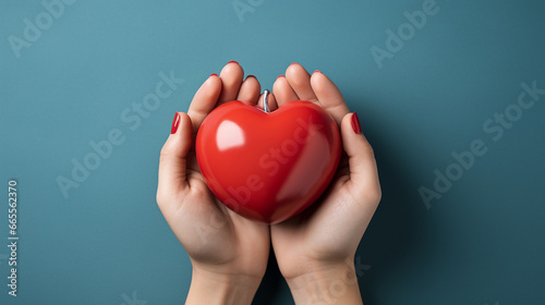 Female hands holding red heart.