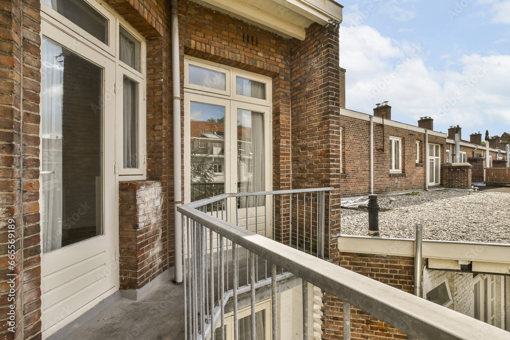 a balcony with brick walls and white trim around the railings, on a sunny day in springtime - stock photo a balcony with brick walls and white trim around the railings, on a sunny day in springtime - stock photo