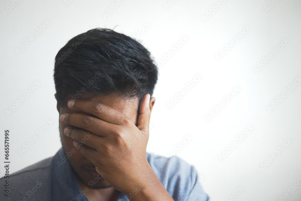 Close up of sad man covering face with hand. Close up of sad man covering face with hand.