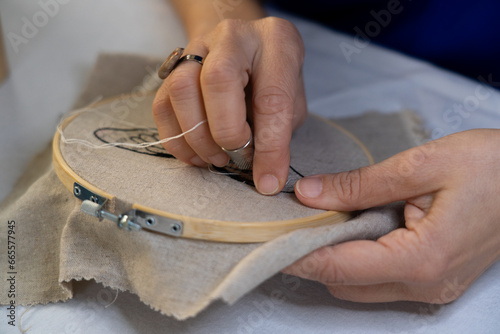 Fényképezés Hands of women embroidering by hand