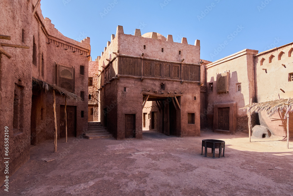 Moroccan red clay fortress in the desert with blue sky.