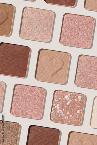 Minimal pattern of eye shadow beige tones swatches, monochrome photo background, eyeshadow with heart imprint, shiny natural shades powder makeup, square shape metal pack, beauty cosmetic texture