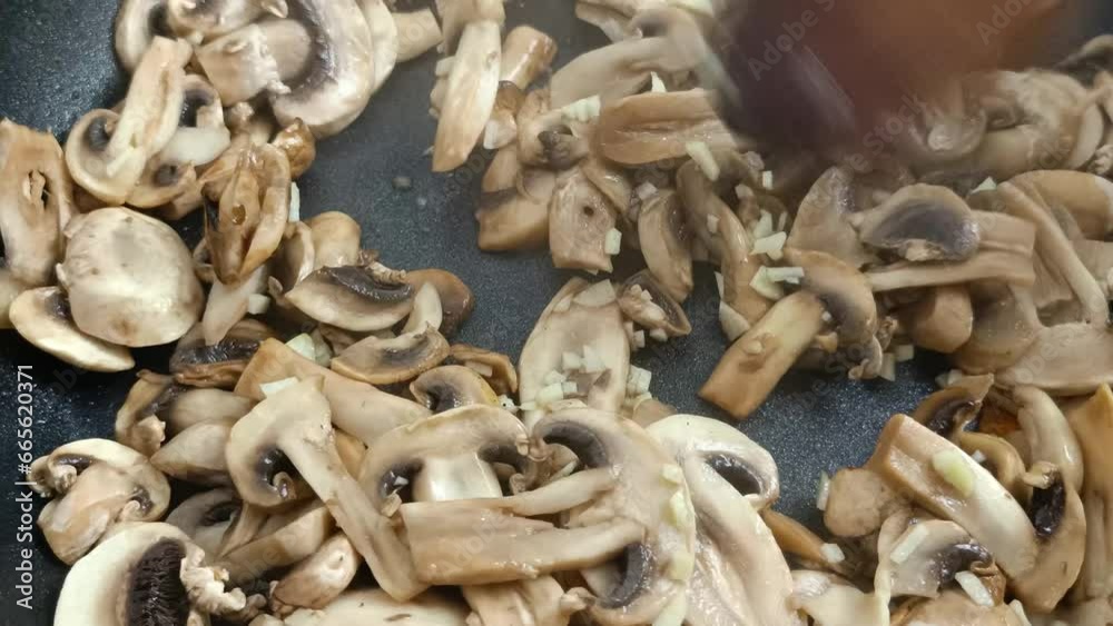 champignons de Paris et ail en cuisson dans une poêle champignons de Paris et ail en cuisson dans une poêle