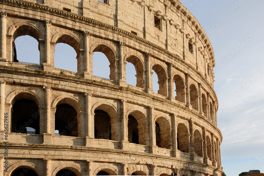 colosseum, historical building in close up with arches and blue sky in Rome, Italy