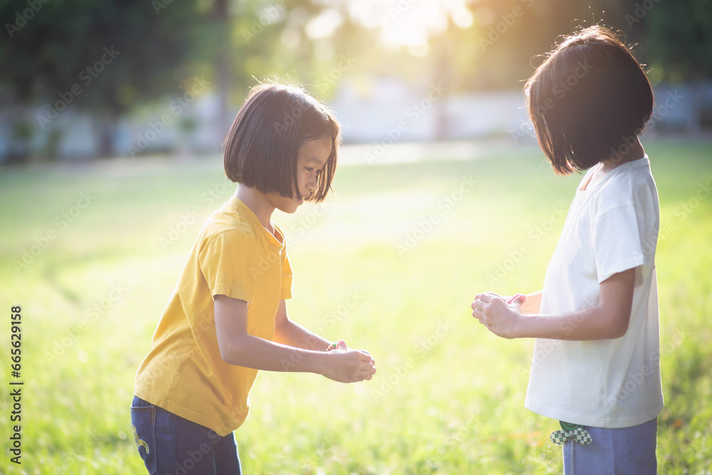 Adorable little siblings play happily on the green grass. Adorable little siblings play happily on the green grass.