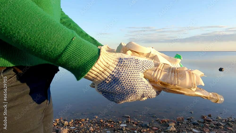 Closeup of an unrecognizable volunteer holding pieces of plastic collected from a polluted beach.