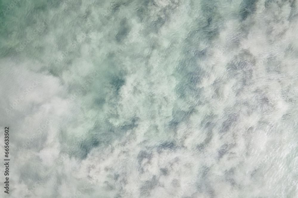 Lake water with swirled dirt with a view from above with small waves