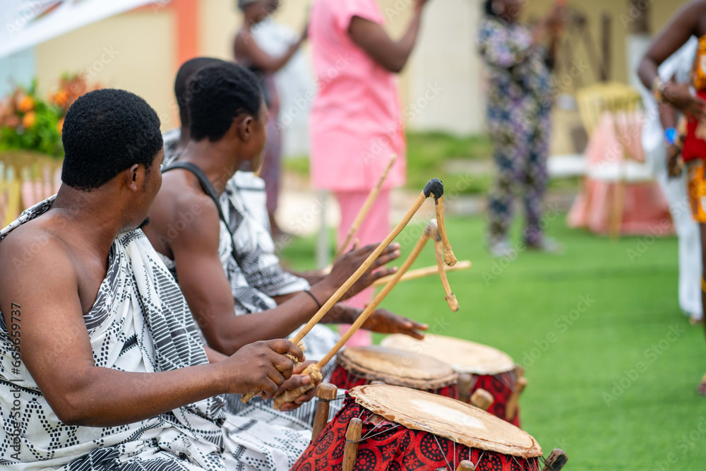 unidentified african musical group outdoor- black guys drumming traditional instrument outdoor
