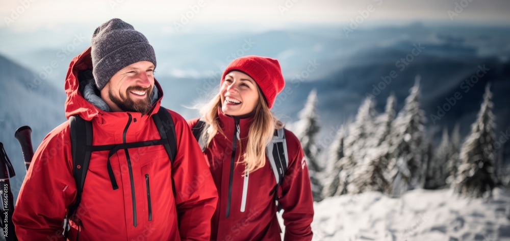 couple smiling standing on top of a snowy mountain after a hike. Adventure and mountain cincept