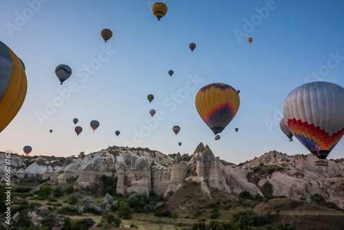 Hot air balloons flying over bizarre rock landscape in Cappadocia. Balloons fly early in the morning. Beautiful hot air balloons in the morning sky. Goreme. Turkey