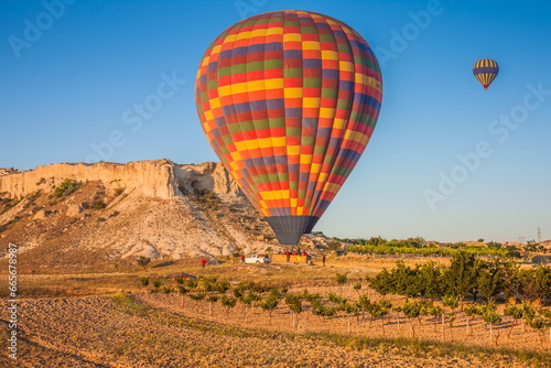 Hot air balloons flying over bizarre rock landscape in Cappadocia. Balloons fly early in the morning. Beautiful hot air balloons in the morning sky. Goreme. Turkey