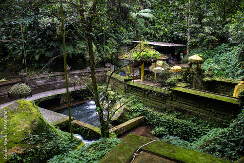 A small temple used for holy ablutions. Haunted and covered in moss, with offerings, beautiful statues and because. Sacred springs and holy water in Bali, Indonesia photo