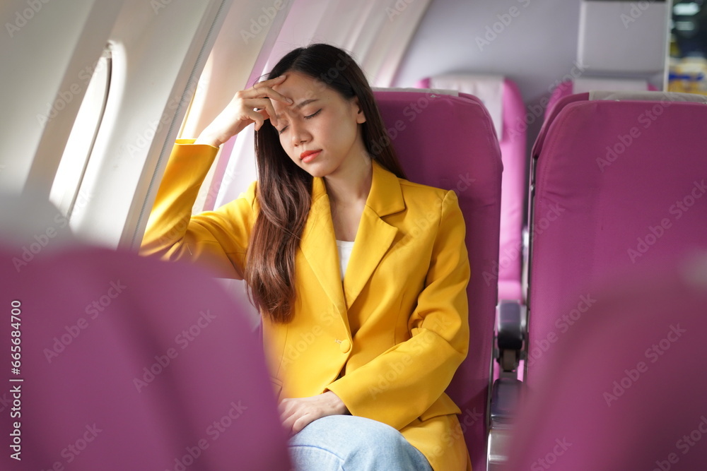 Asian woman sitting on airplane playing with cell phone and looking out window on vacation travel concept Talk about business on airplanes, listen to music, watch movies, relax, travel. Asian woman sitting on airplane playing with cell phone and looking out window on vacation travel concept Talk about business on airplanes, listen to music, watch movies, relax, travel.