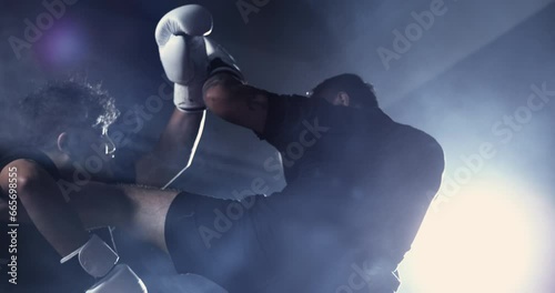 Man fighting during Muay Thai training match, boxer falling to the ground defeated after leg kick, dramatic lighting with ultra slow-motion speed ramp at 800 fps
