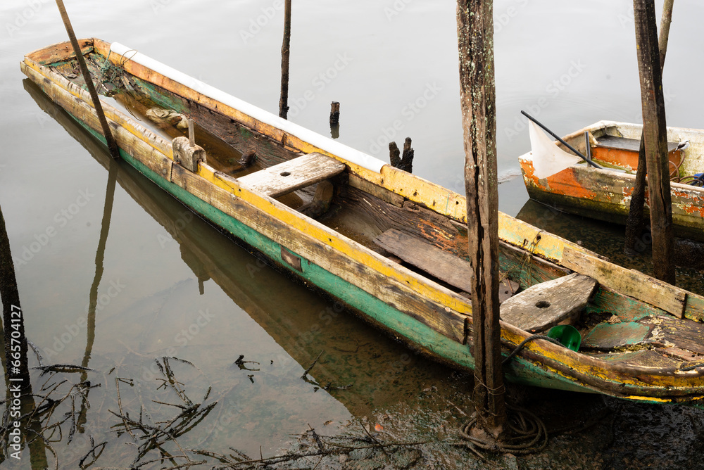 A fishing and transport canoe stops on the riverbank.