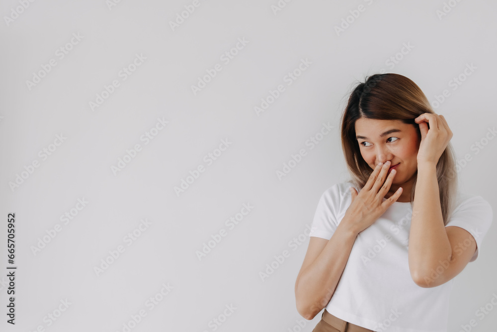 Happy asian Thai woman smiling look at camera, tucking hair behind ear and hand covering mouth lips, ashamed shy and embarrassing, isolated on white background. Happy asian Thai woman smiling look at camera, tucking hair behind ear and hand covering mouth lips, ashamed shy and embarrassing, isolated on white background.