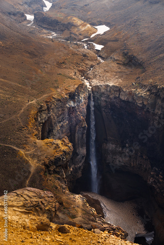Beautiful landscape of Kamchatka Peninsula: view of Dangerous Canyon , picturesque waterfall on the river Vulkannaya under the active Mutnovsky Volcano.