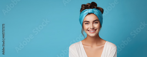 Leinwand Poster Young beautiful smiling woman in trendy headband on head isolated on flat color background with copy space