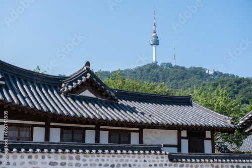 Traditional Korean building in Namsangol Hanok village, with view of N Seoul Tower or Namsan Tower in Seoul, South Korea.