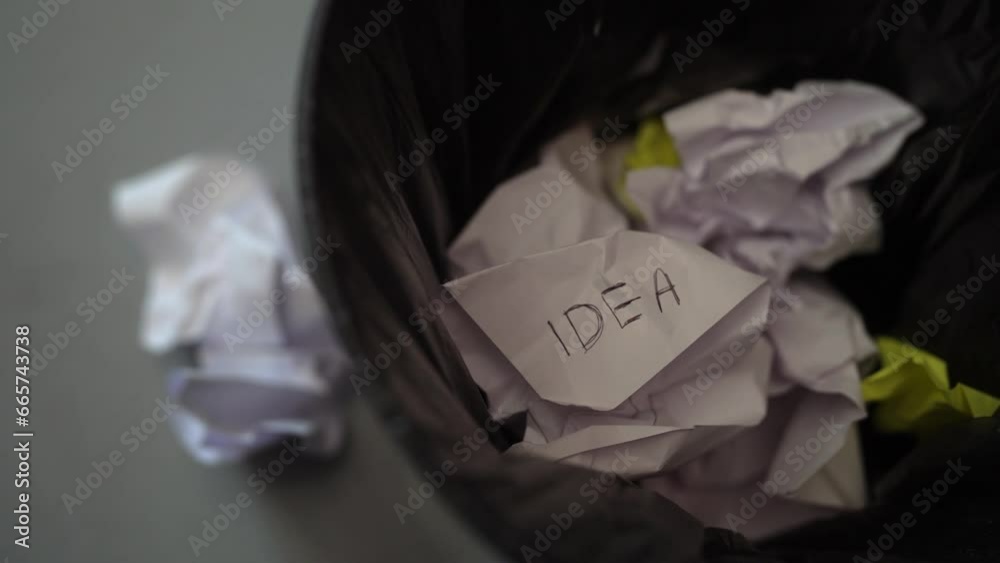unworthy planning idea on crumpled paper thrown in trash bin, close up