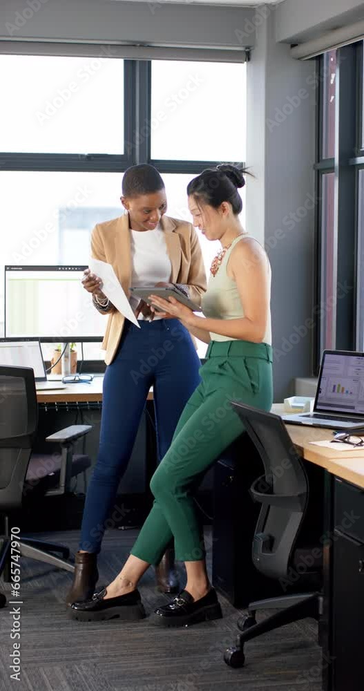 Vertical video of casual diverse business people working together in office, slow motion, copy space Vertical video of casual diverse business people working together in office, slow motion, copy space