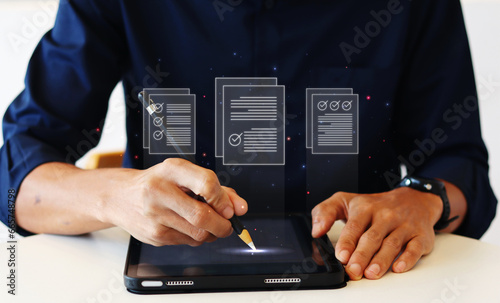 Businessman using a ipad and touching on virtual screen filling survey form audit online documents, quality assessment management With a checklist, business document evaluation process.