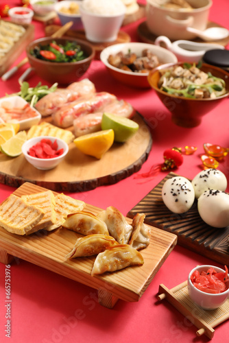 Composition with delicious Chinese dishes on red background