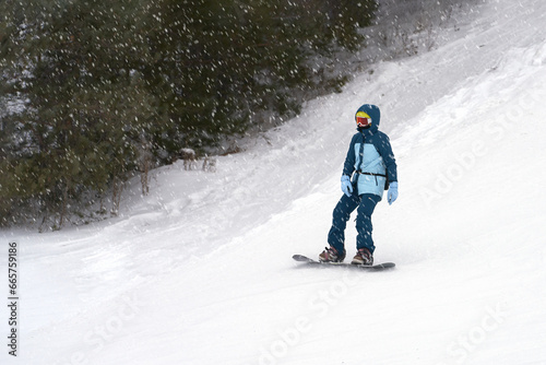 A lone snowboarder on a snowy slope. Copy space.