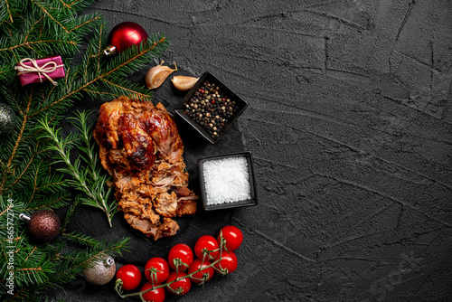 Christmas pork cooked in the oven against the background of a Christmas tree and Christmas toys with copy space for your text