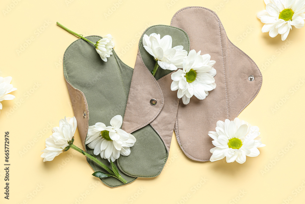 Composition with reusable menstrual pads and chamomile flowers on color background Composition with reusable menstrual pads and chamomile flowers on color background