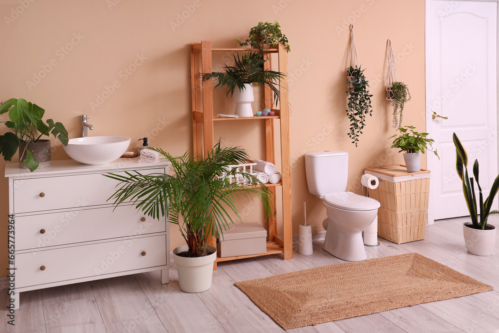 Interior of restroom with toilet bowl, shelf unit and sink Interior of restroom with toilet bowl, shelf unit and sink