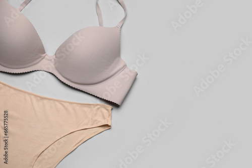 Stylish female panties and bra on grey background, closeup