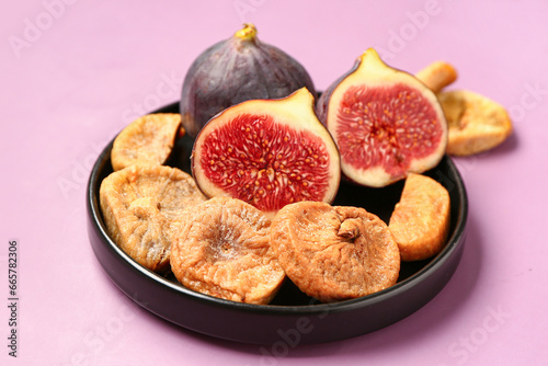Fototapeta Naklejka Na Ścianę i Meble -  Plate with sweet dried figs and fresh fruits on purple background