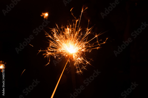 Sparklers on a black background. New year s night. Festive mood. Time of surprises and bright lights.