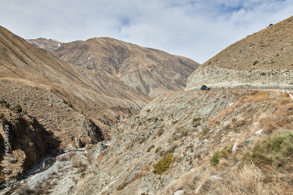 Gravel road in the mountainside. Travelling by car