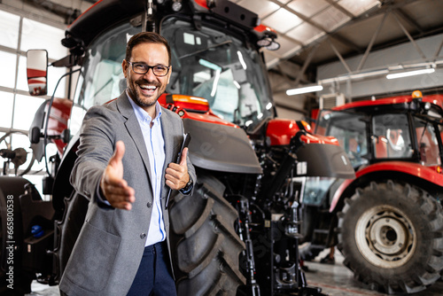 handsome caucasian man in business suit selling tractors and farming equipment.