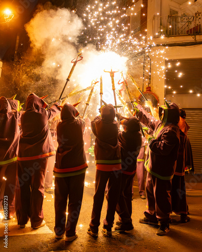 Diables con fuegos artificiales en la calle en fiestas mayores