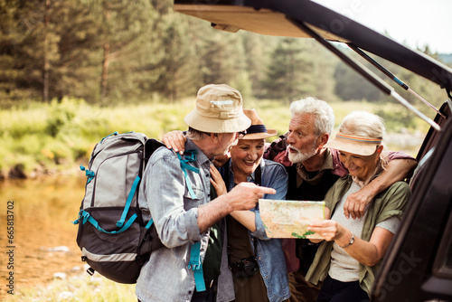 Group of active seniors looking at a map on a hike in nature photo