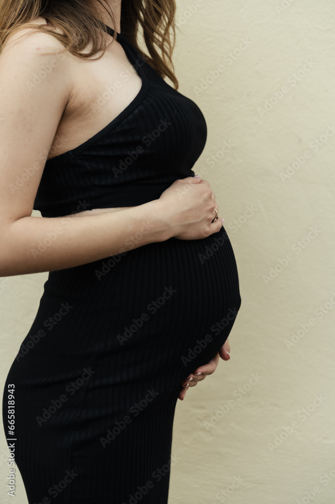 pregnant woman hugs her stomach with her hands. close-up of hands lying on a pregnant belly. pregnant couple expecting a newborn pregnant woman hugs her stomach with her hands. close-up of hands lying on a pregnant belly. pregnant couple expecting a newborn
