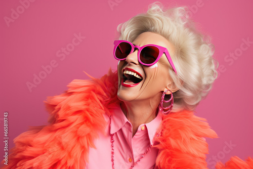 Happy senior woman in colorful pink outfit, cool sunglasses