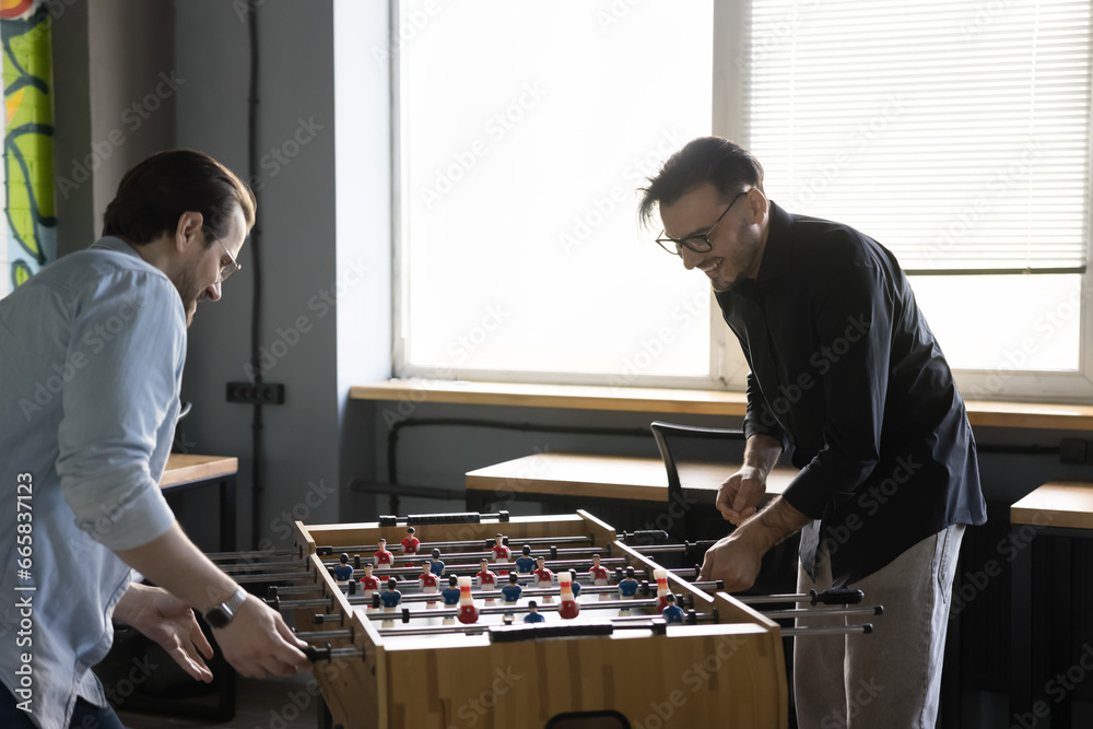 Two positive excited colleagues having fun at workplace during lunch ...