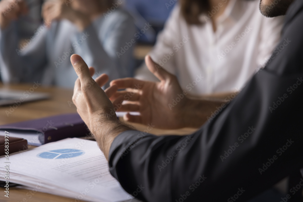 Close-up unknown businessman expresses professional opinion at group meeting, explain professional point of view, discuss business agreement with colleagues, share ideas. Team work process, business