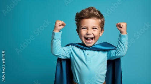 A young boy wearing a superhero costume stands in a triumphant pose