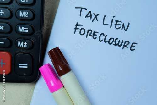 Concept of Tax Lien Foreclosure write on book isolated on Wooden Table.