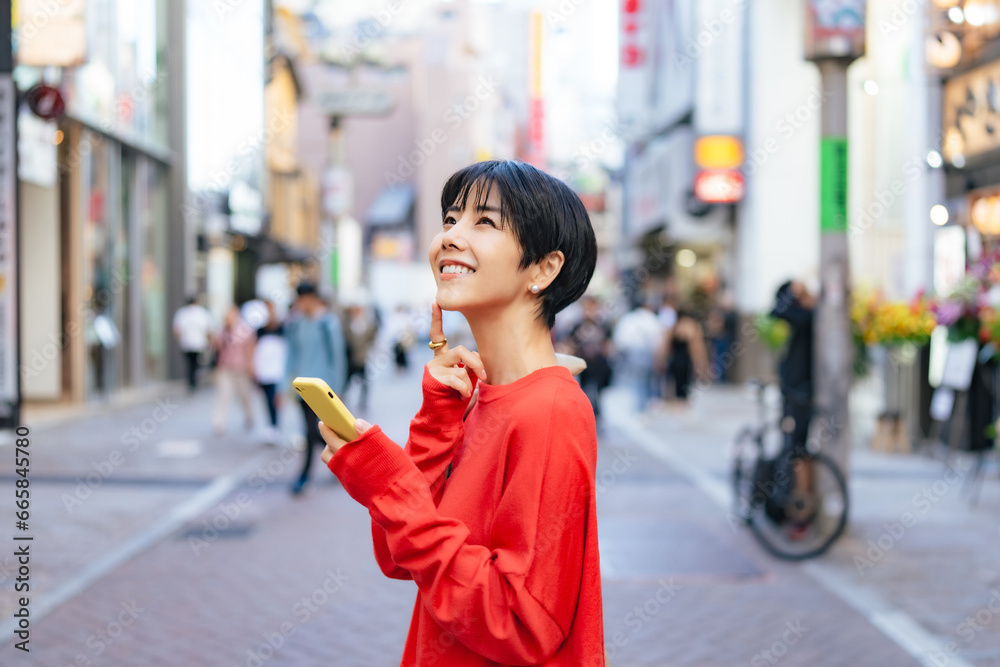 Fototapeta premium 街中でスマホを使う女性